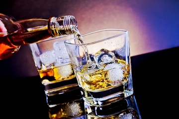 barman pouring whiskey into glass on light tint blue disco