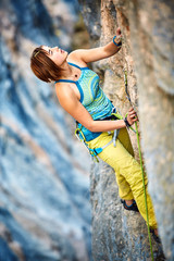 Rock climber climbing up a cliff