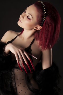 Beautiful sexy woman with red hair and long nails in fur coat