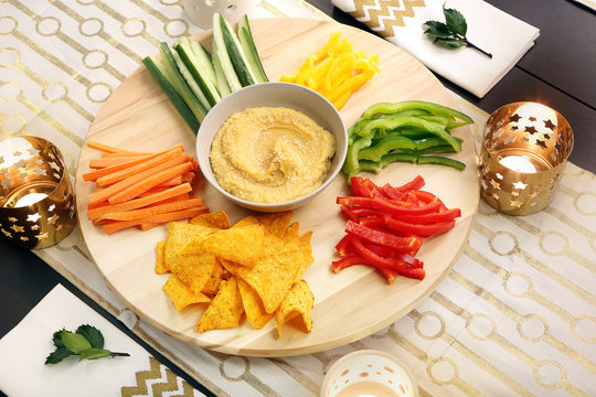 Hummus with vegetables on a wooden swivel table