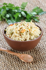 rice with vegetables in a ceramic bowl on a mat