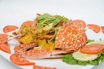 Fried crab in yellow curry on white plate,