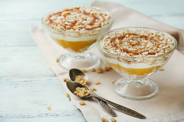 Tasty dessert with oat flakes and honey, on table