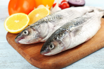 Fresh raw fish and food ingredients on table