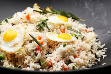 Tasty rice preparing in wok, close-up