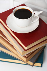 Pile of books with cup of hot drink