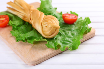 Smoked braided cheese on wooden table