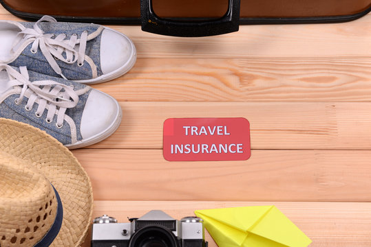 Suitcase and tourist stuff with inscription travel insurance