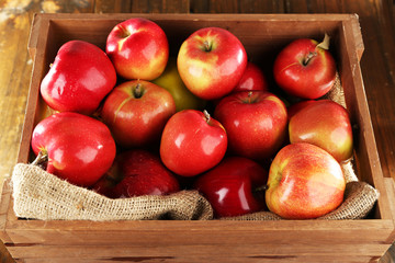 Red apples in wooden crate with burlap cloth