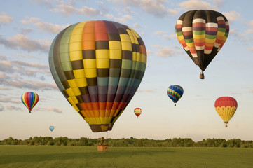 Fototapeta premium Various hot-air balloons floating over a field
