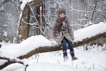 Fototapeta na wymiar Happy little girl on the background of a winter park