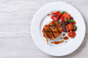 Fried piece of pork with vegetable salad, top view horizontal