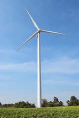 Fototapeta na wymiar wind turbine against cloudy blue sky background