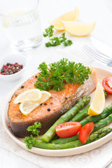 baked salmon with asparagus, parsley and lemon, top view