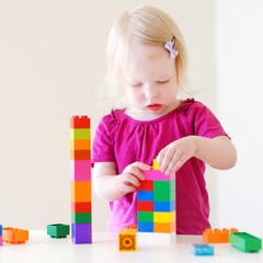 Cute toddler girl playing with colorful blocks