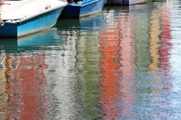 Fototapeta na wymiar Colorful houses on BURANO island reflected on the water and some