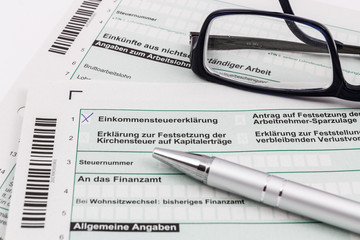 Obraz premium Formular Einkommensteuererklärung mit Kugelschreiber und Brille