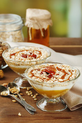 Tasty dessert with oat flakes and honey, on table
