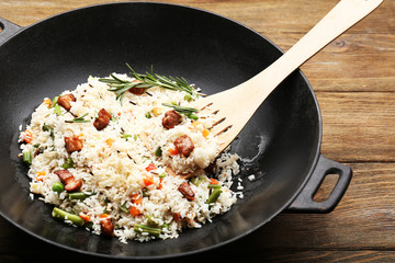 Tasty rice preparing in wok, close-up