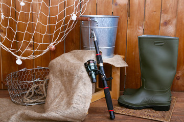 Fishing equipment on wooden wall background, indoors