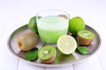 Glass of fresh lime juice with pieces of lime and kiwi