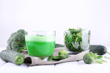 Glass of green smoothie and herbs with vegetables
