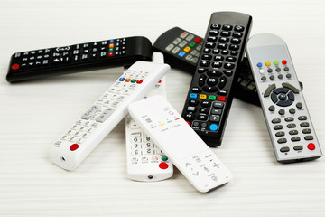 Many remote control devices on table