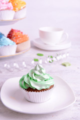 Delicious cupcakes on plate on table close-up