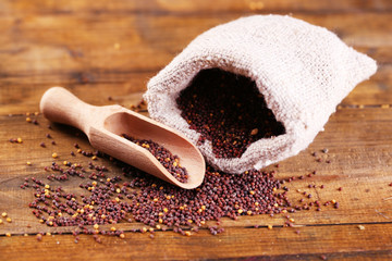 Mustard seeds in bag on  wooden background