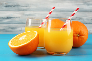 Glass of orange juice with straws and slices