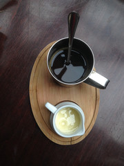 Cup of black coffee and milk on the wooden table