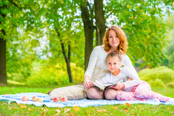 Beautiful mother and daughter spend a weekend at a picnic in the