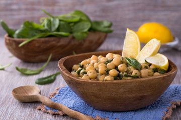 Spiced chickpeas with spinach in a wooden bowl © olepeshkina