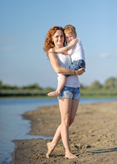 Happy Mom and baby son in summer nature