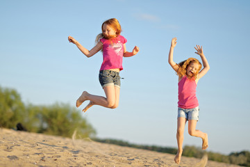 portrait of two sisters walking on the beach