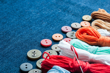 Blue jeans background with buttons and threads.