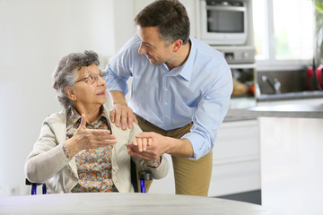 Homecarer supporting elderly woman at home