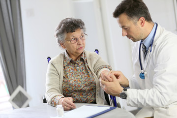 Doctor checking blood pressure to elderly woman