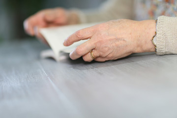 Fototapeta na wymiar Closeup of elderly woman's hands with book