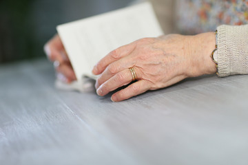 Fototapeta na wymiar Closeup of elderly woman's hands with book