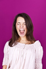 Portrait of beautiful woman screaming with wide open mouth