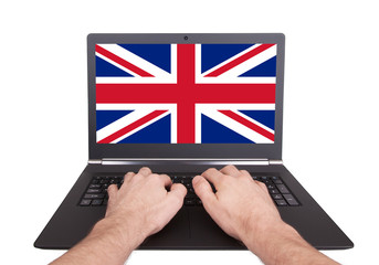 Hands working on laptop, United Kingdom