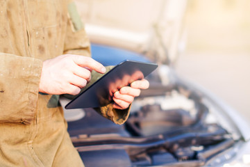 Man Using Touchscreen Tablet For Car Diagnostics