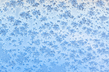 Fototapeta na wymiar snowflakes and frost on window with blue sky