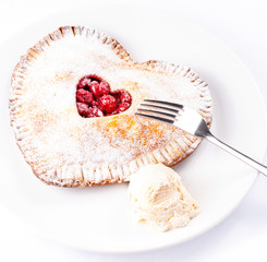 Heart shaped cherry pie with vanilla ice cream on white