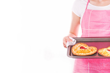 Woman holding hands a pan with heart shaped cherry pies