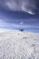 Fototapeta na wymiar white cross at the top of a snowy mountain