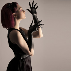 Beautiful woman with red hair and black paint on hands