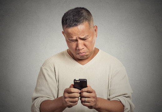 sad upset man seeing bad news email text on cellphone