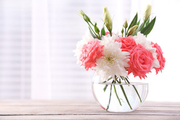 Beautiful flowers in vase with light from window
